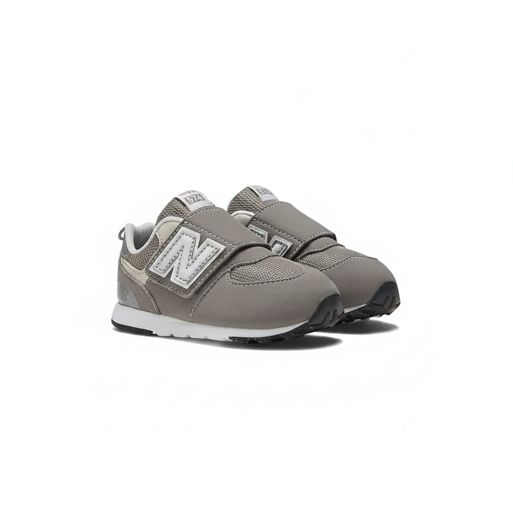 Grey New Balance 574 children's sneakers with white "N" logo, hook-and-loop straps, and black soles.