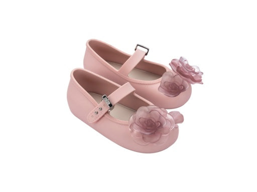 Pair of light pink baby ballerina shoes with a clear pink floral embellishment on the toe and a silver buckle strap.