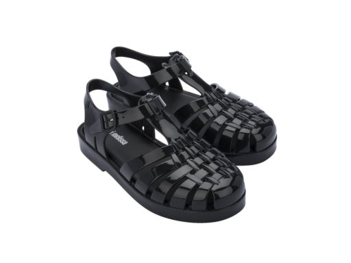 Pair of shiny black Mini Melissa jelly sandals with a woven toe box and an adjustable ankle strap.