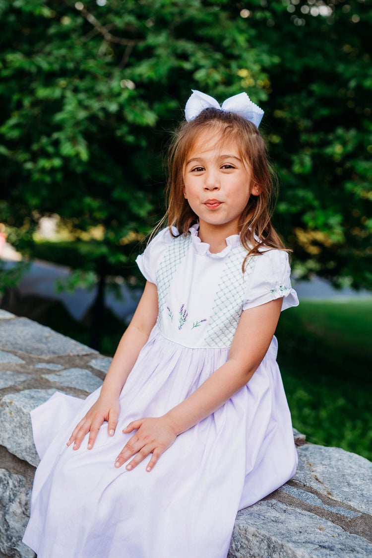 Girl wearing a large white hair bow outdoors