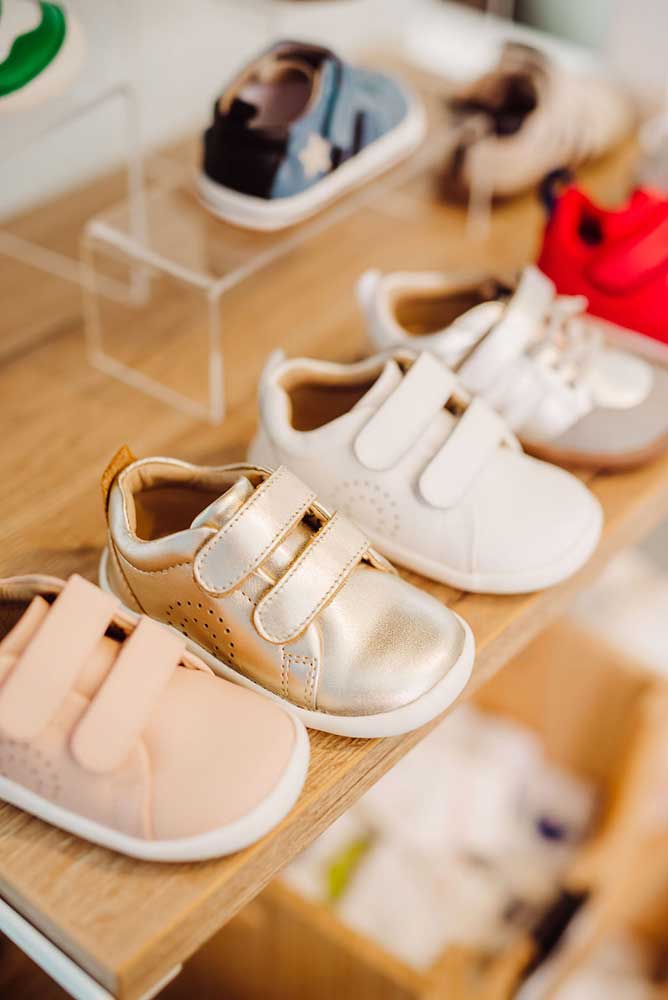Parent playing outdoors with toddler and young child in shoes