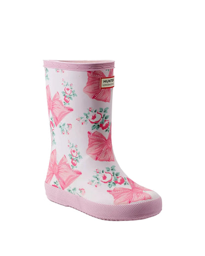Pink and white Hunter x LoveShackFancy Kids' First Classic Rain Boot with a floral and bow pattern.