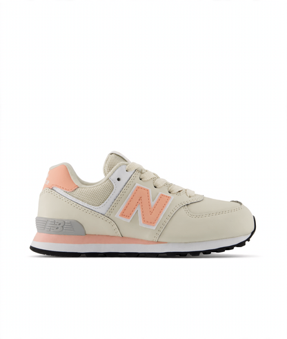 New Balance 574 Core Lace little kids' sneaker in cream with peach accents, grey heel, and white midsole.