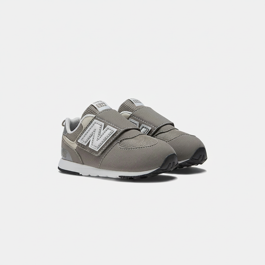 Grey New Balance 574 children's sneakers with white 'N' logo, silver accents, and hook & loop straps.