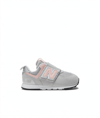 Light gray and pink New Balance 574 children's sneaker with a Velcro strap featuring the 'N' logo and an 'NB' logo on the heel.