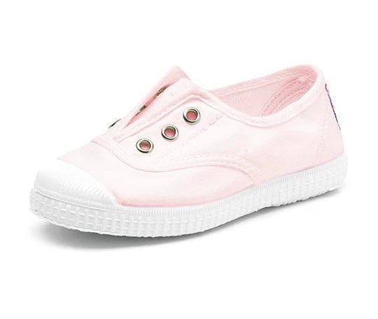 Light pink canvas slip-on children's shoe with white rubber toe cap and sole, featuring three silver eyelets on the vamp.