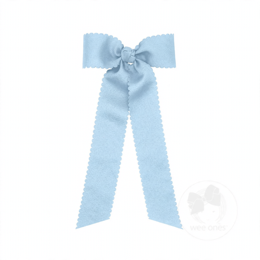 Light blue grosgrain hair bow with scalloped edges, a knot wrap center, and long streamer tails.