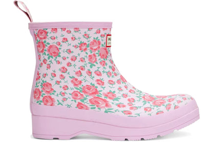Pink Hunter x LoveShackFancy women's short rain boot with a delicate pink rose and green leaf floral pattern, featuring a pink sole and pull tab.