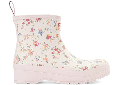 White Hunter x LoveShackFancy short rain boot with a multi-colored floral pattern, light pink trim, and a pull tab.