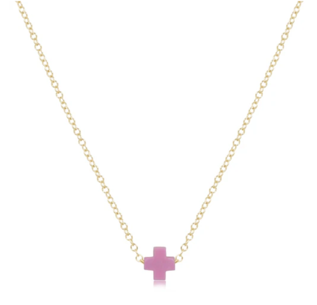 Delicate gold chain necklace with a small, flat, light pink cross pendant centered on a white background.