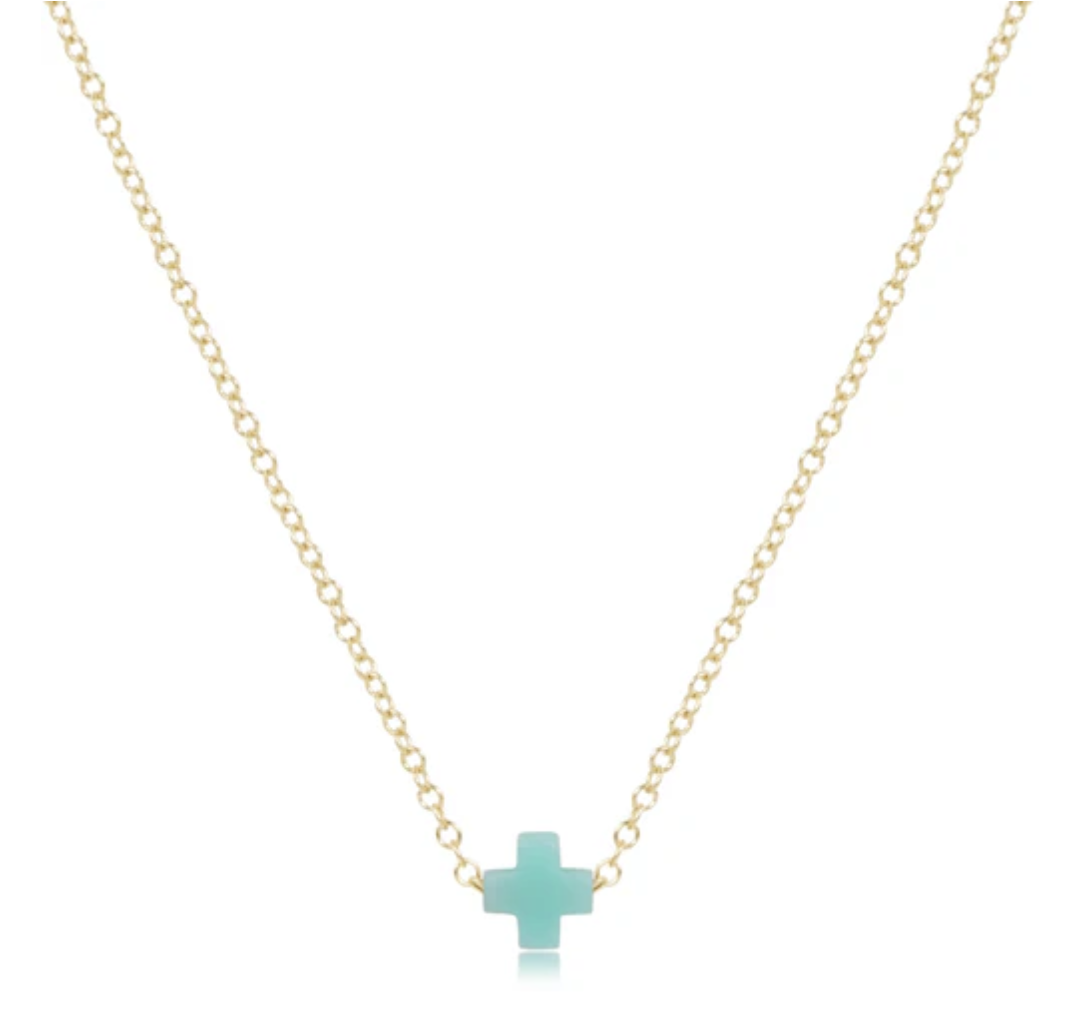 Delicate gold chain necklace featuring a small, flat, light blue cross pendant.