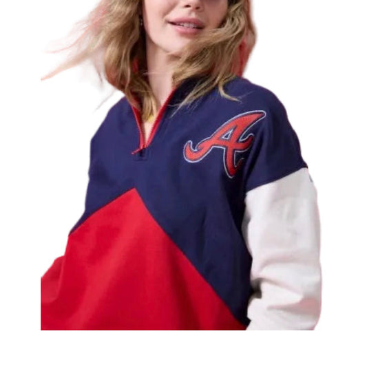 Smiling woman in a navy and red Braves baseball cap and a navy, red, and white colorblock quarter-zip sweatshirt with a red 'A' logo.