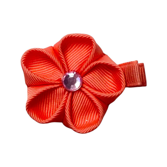 Orange grosgrain ribbon flower hair clip with a clear pink gem in the center and a small clip on the side.