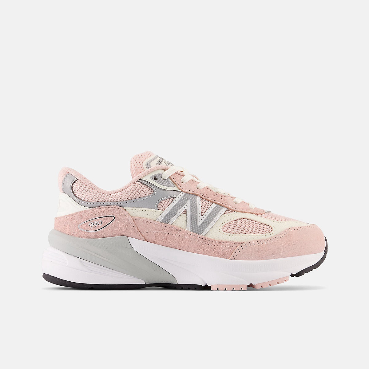 New Balance Fuelcell 990v6 big kids' sneaker in pink, white, and grey, featuring a prominent 'N' logo and '990' on the heel.