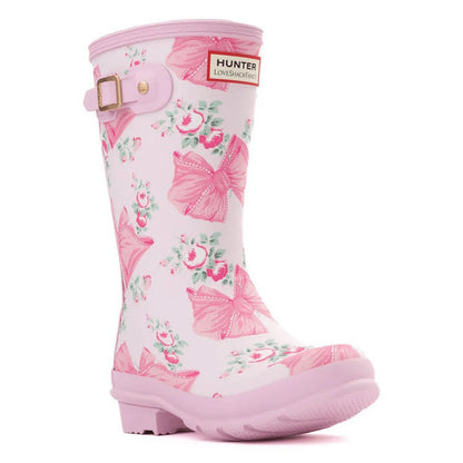 Pink and white Hunter x LoveShackFancy children's rain boot with a floral and bow pattern, featuring a pink buckle and logo.