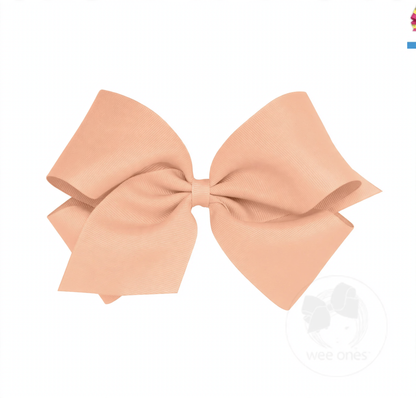 Large peach grosgrain hair bow with a classic ribbed texture and symmetrical loops.