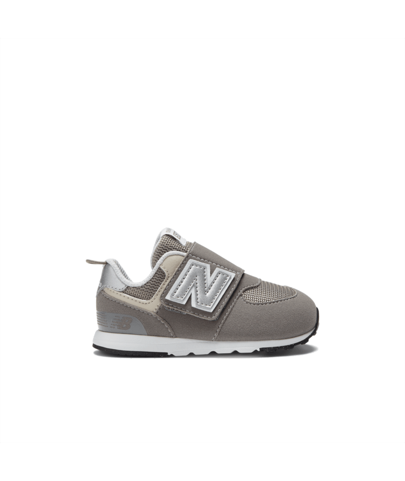 Grey New Balance 574 children's sneaker featuring a silver N logo, hook-and-loop strap, and white midsole.