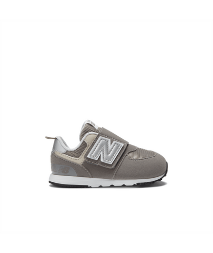Grey New Balance 574 children's sneaker featuring a silver N logo, hook-and-loop strap, and white midsole.