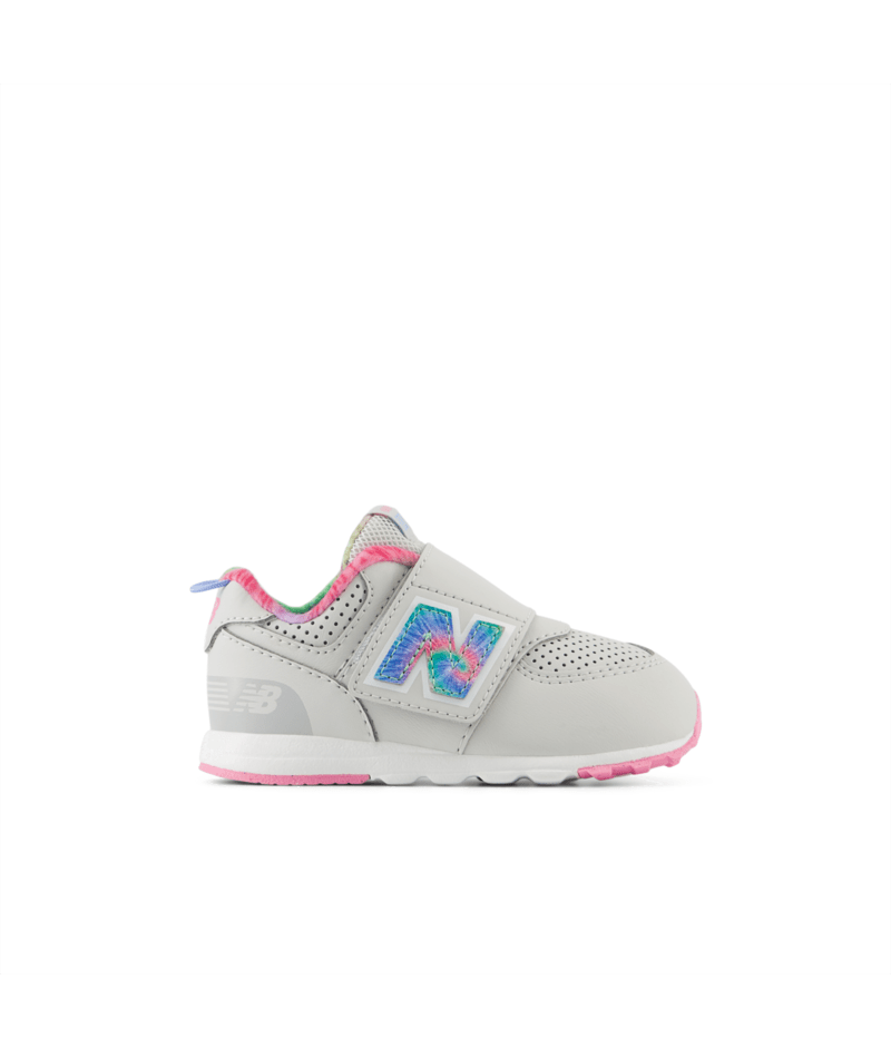 Light gray New Balance 574 children's sneaker with a tie-dye 'N' logo, pink accents, and a hook-and-loop closure.
