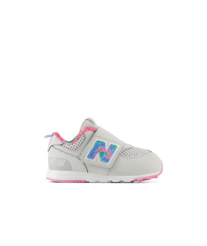 Light gray New Balance 574 children's sneaker with a tie-dye 'N' logo, pink accents, and a hook-and-loop closure.