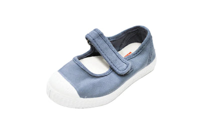 Children's blue canvas Mary Jane shoe with a white rubber toe cap, white sole, and a single Velcro strap.