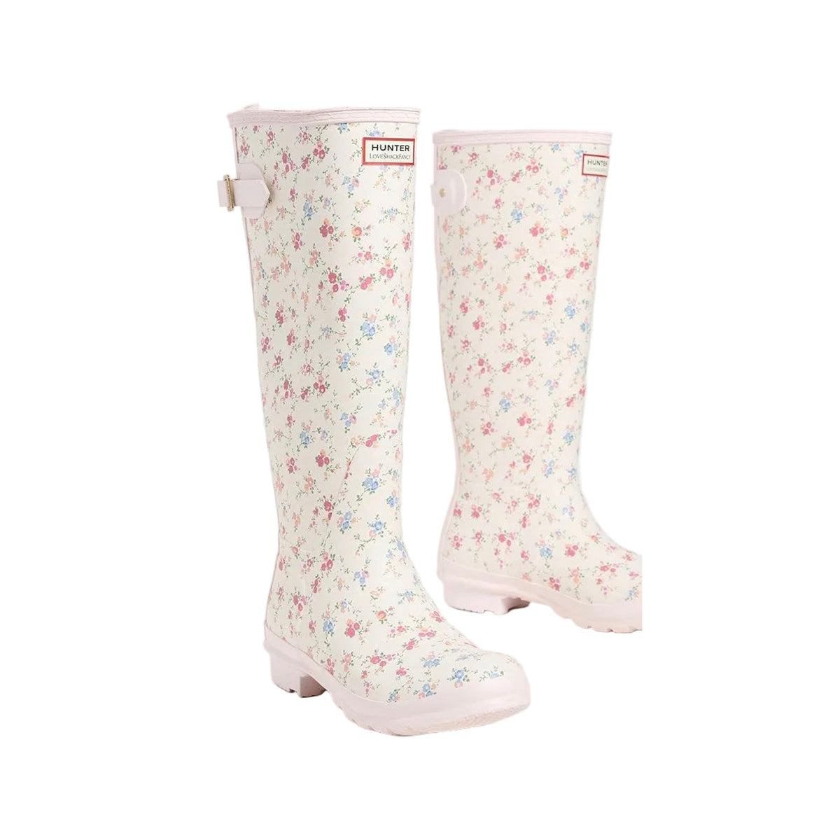 Tall rain boots with a cream base, small pink and blue floral print, pink sole, and a Hunter x LoveShackFancy logo patch.