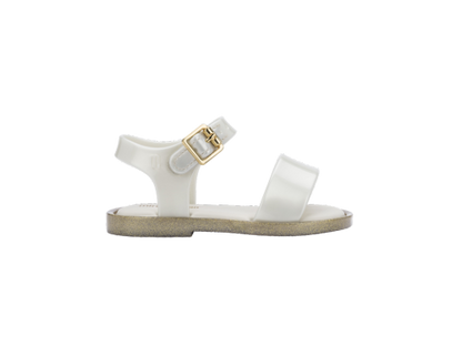 Mini Melissa Mar baby sandal in translucent white with a glittery gold sole and a gold buckle on the ankle strap.