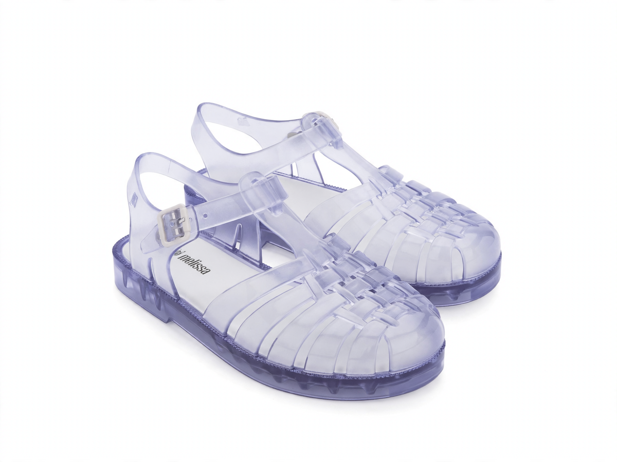 Pair of clear, slightly purple-tinted Mini Melissa jelly sandals with a woven toe, ankle strap, and silver buckle.
