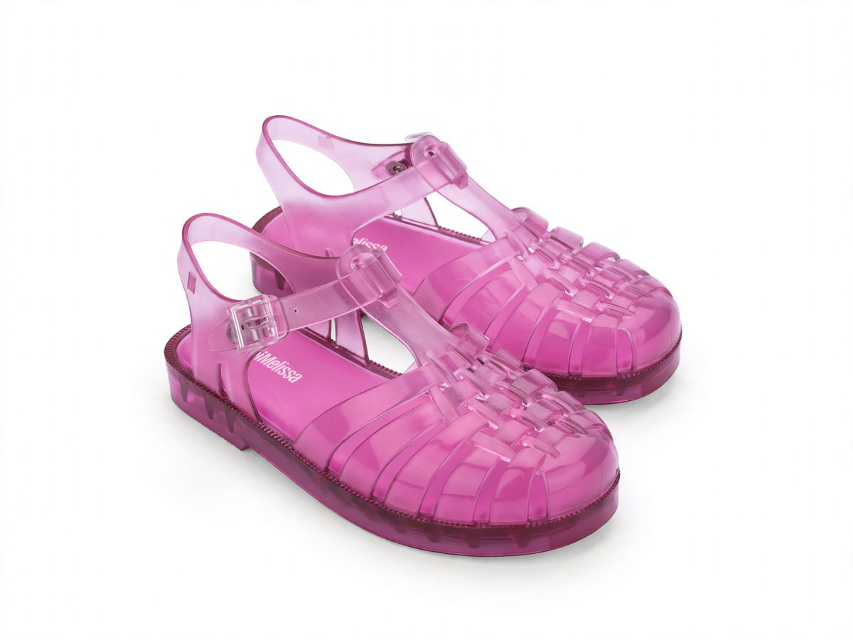Pair of shiny translucent pink Mini Melissa Possession jelly sandals with a woven toe and ankle buckle strap.