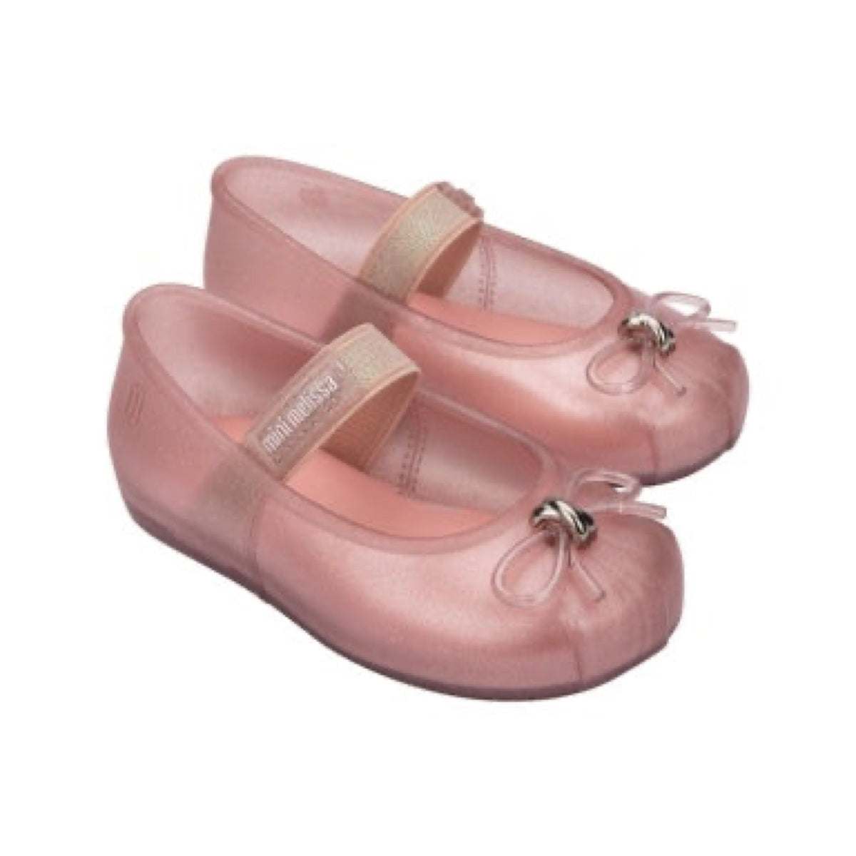 Pair of glittery pink Mini Melissa Mary Jane jelly flats with a gold strap featuring 'mini melissa' text and a clear bow with silver hardware.