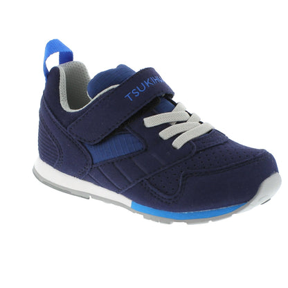 Navy blue children's athletic shoe with a light blue pull tab, grey elastic laces, and a Velcro strap featuring the Tsukihoshi logo.
