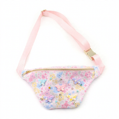 Children's floral fanny pack with a pink strap, gold zipper, and colorful 3D butterfly and pearl embellishments.