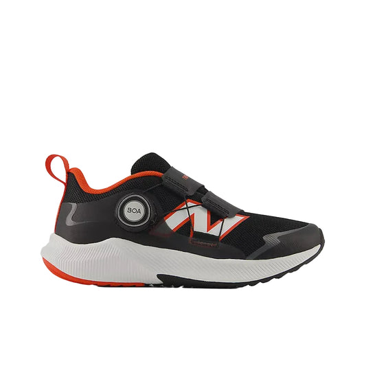 Black and white New Balance children's athletic shoe with orange accents, a BOA fit system dial, and hook-and-loop straps.