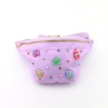 Lavender fanny pack adorned with colorful candy, star, and shell embellishments, and a gold zipper.