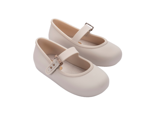Pair of light beige Mini Melissa Soft Ballerina baby shoes with a single strap and buckle closure.