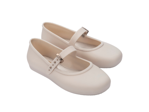 Pair of light beige Mini Melissa Soft Ballerina shoes with a single strap and silver buckle on a white background.