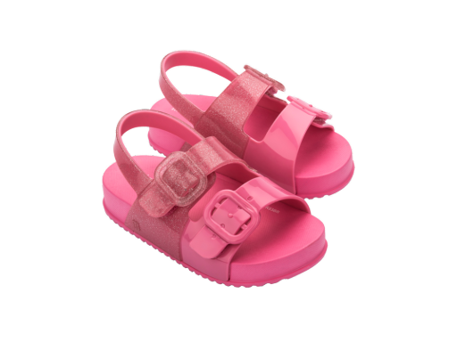 Pair of bright pink children's jelly sandals with chunky soles, two wide straps, and large square buckles, one strap on each sandal is glittery.