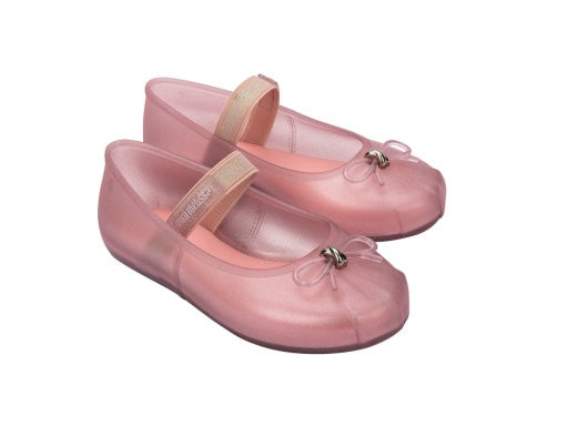 Two translucent pink Mini Melissa Sophie ballet flats with beige Mary Jane straps featuring 'mini melissa' branding and small bows on the toes.