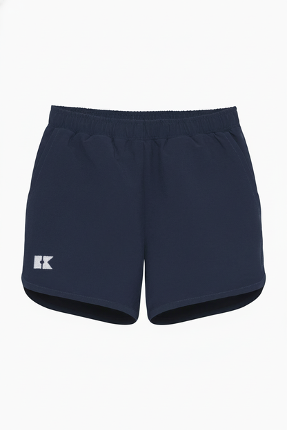 Navy blue athletic shorts with an elastic waistband, side pockets, a white logo on the left leg, and a curved hem.