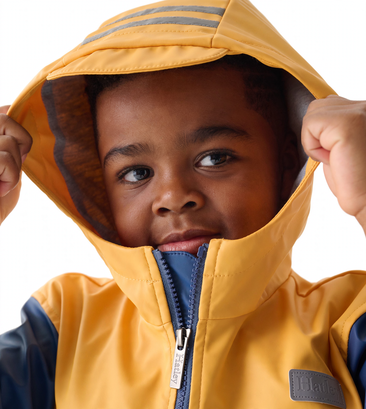 Yellow and navy zip-up rain jacket with a hood, featuring gray stripes and a front zipper, worn by a child.